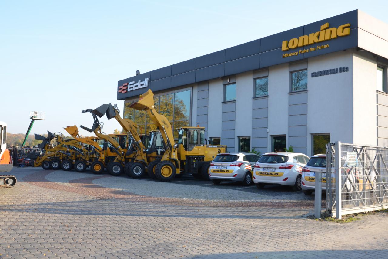 Żółte wózki widłowe marki Lonking ustawione przed budynkiem firmy Eddi z logo i adresem na fasadzie, na parkingu zaparkowane samochody z logo Lonking.pl.