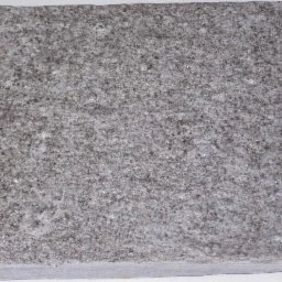 Szara, kwadratowa płyta chodnikowa z wyraźną, ziarnistą fakturą na białym tle.