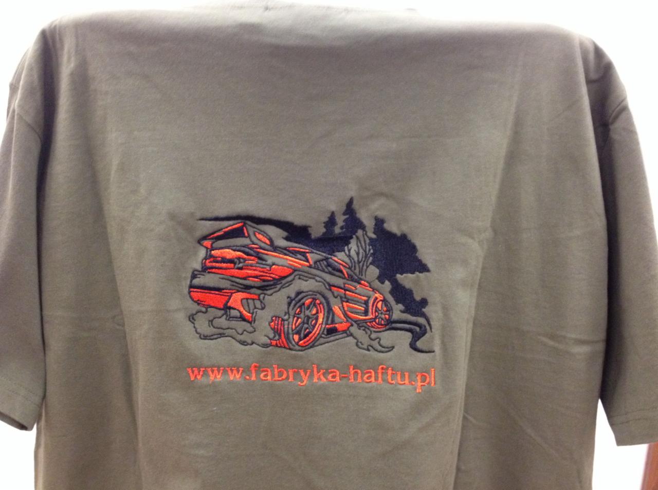 Khaki koszulka z haftowanym, pomarańczowo-czarnym wzorem samochodu w stylu driftu i adresem strony internetowej 'www.fabryka-haftu.pl' poniżej.