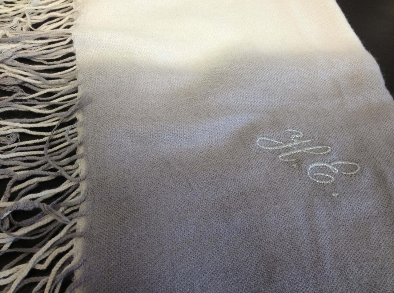 Szaro-biały szal z frędzlami i wyhaftowanym monogramem 'H.C.'