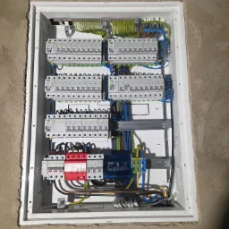 Rozdzielnica elektryczna z zabezpieczeniami w obudowie, widok z góry, szczegóły instalacji elektrycznej. Prace elektryczne w Gdyni.