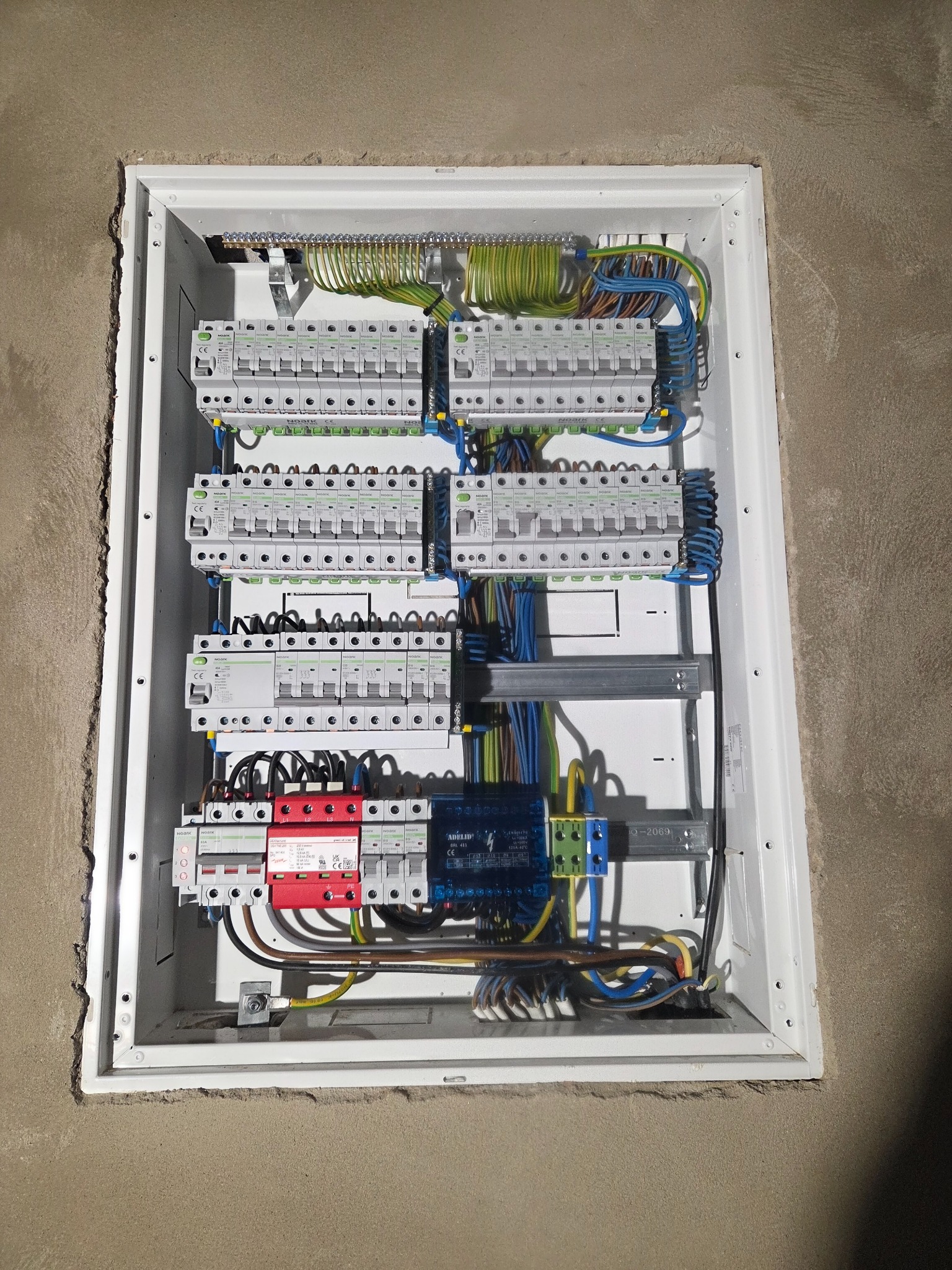Rozdzielnica elektryczna z zabezpieczeniami w obudowie, widok z góry, szczegóły instalacji elektrycznej. Prace elektryczne w Gdyni.