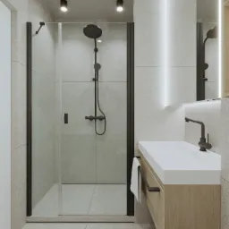 Minimalistyczna łazienka z kabiną prysznicową w czarnej ramie, umywalką na szafce z drewnianym frontem i oświetleniem LED za lustrem.