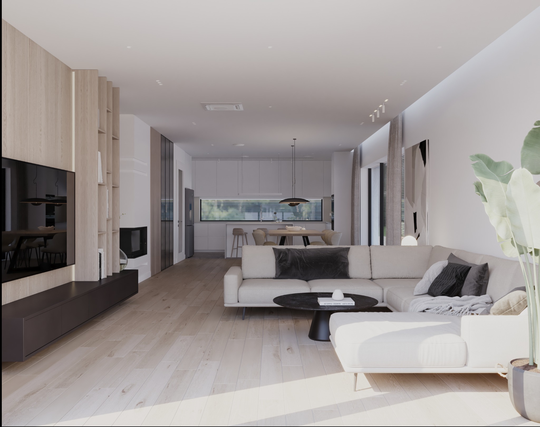 Jasne, przestronne wnętrze salonu z aneksem kuchennym, beżowa sofa narożna z poduszkami, okrągły stolik kawowy, drewniana podłoga i zabudowa telewizyjna z regałem.