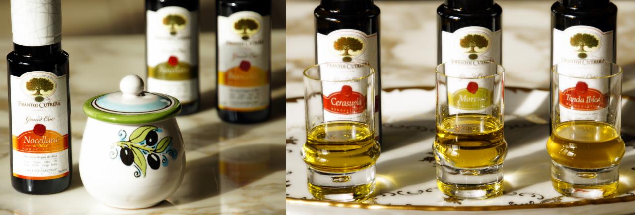 Eleganckie butelki oliwy Frantoi Cutrera obok ceramicznego pojemnika z motywem oliwek i kieliszków z oliwą na marmurowym blacie.