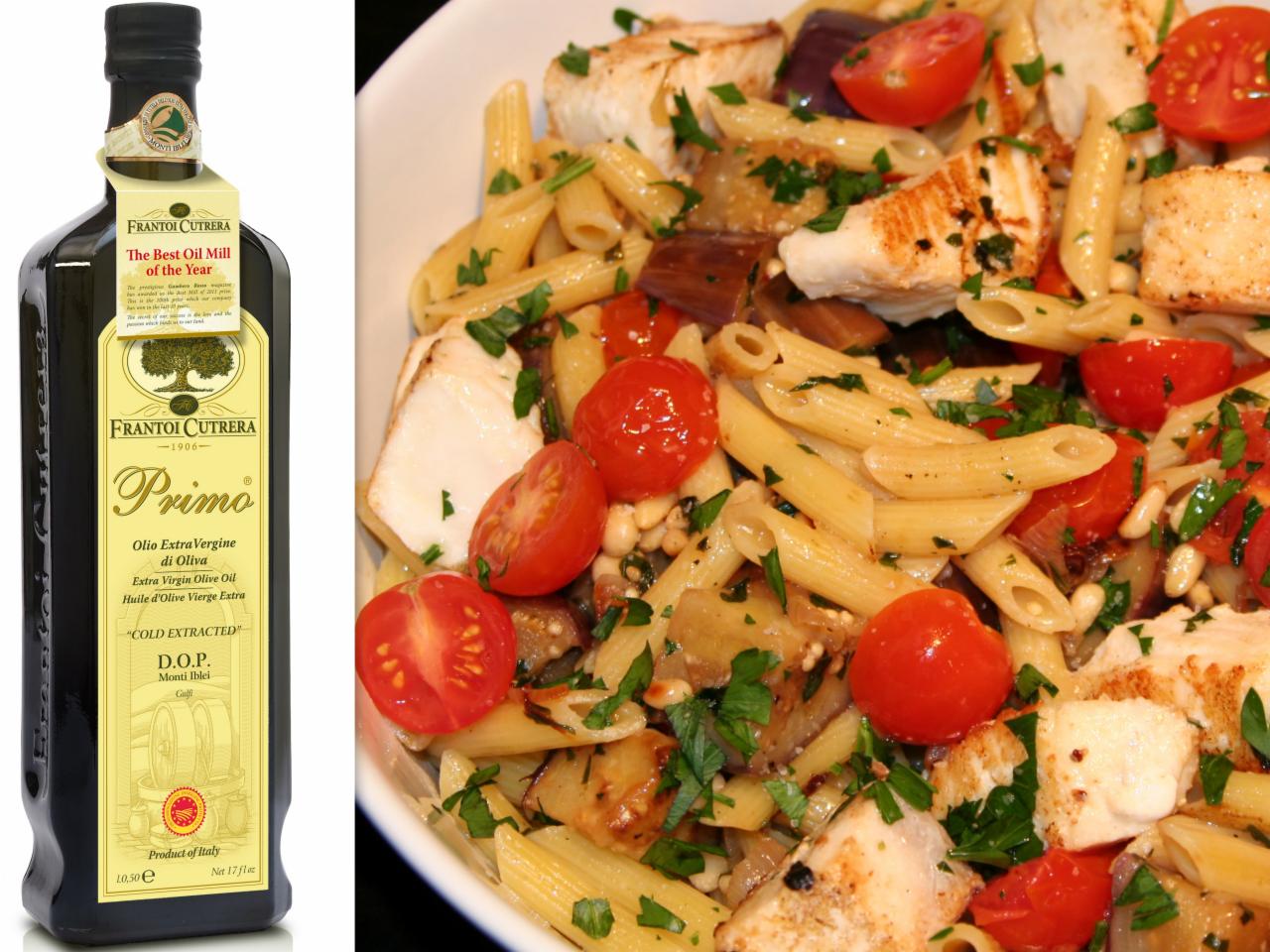 Elegancka butelka oliwy Frantoi Cutrera Primo obok talerza makaronu penne z grillowanym kurczakiem, pomidorami i bakłażanem. Całość skropiona oliwą z oliwek.