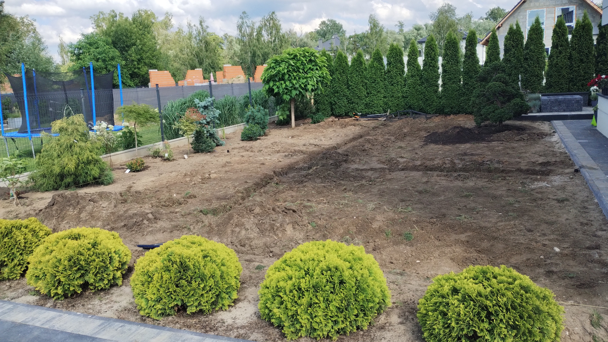 Teren podczas prac, wykonane nasadzenia, zainstalowany system nawadniania.