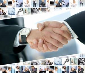 Uścisk dłoni na tle kolażu zdjęć biznesowych, widoczny zegarek na ręce, symbol współpracy i porozumienia.