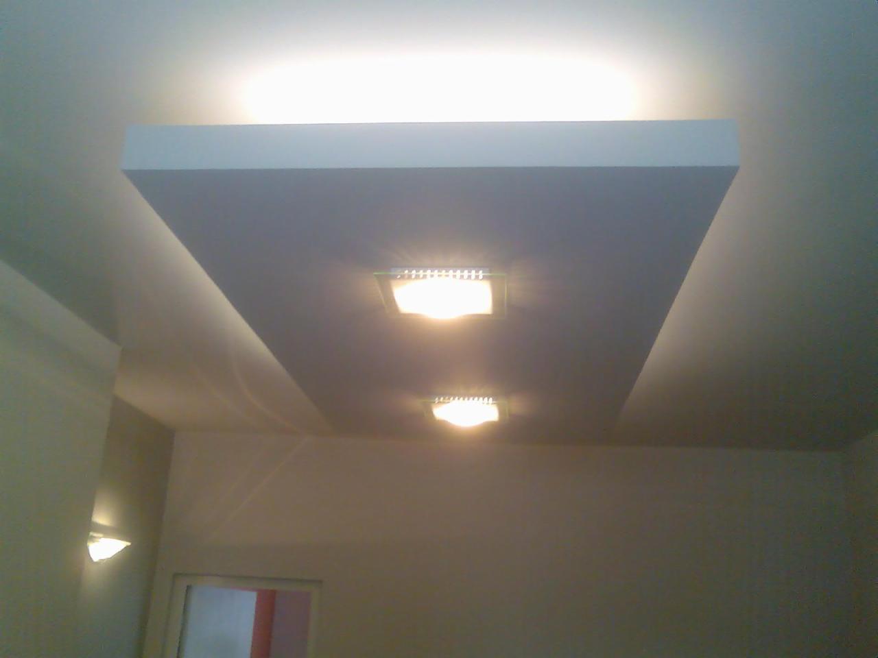 Prosty, biały sufit podwieszany z dwoma punktowymi lampami LED w Zagnańsku, widok z dołu.