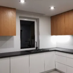 Nowoczesna kuchnia z białymi szafkami dolnymi i górnymi szafkami z naturalnego drewna, czarnym blatem i czarną armaturą, oświetlona punktowymi lampami sufitowymi i listwą LED pod szafkami górnymi.