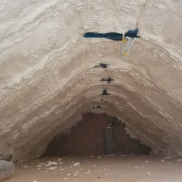 Poddasze po ociepleniu pianą PUR otwartokomórkową, widoczne kable elektryczne zabezpieczone żółtą taśmą i fragment muru z cegły.