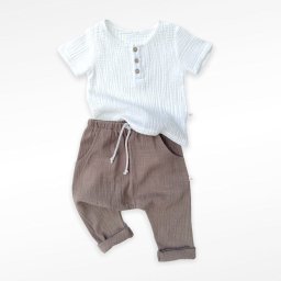 LUPUS Magdalena Bajor-Wilk - Zestaw dziecięcy z białej koszulki z trzema drewnianymi guzikami i brązowych spodni z kieszeniami i sznurkiem, leżący na białym tle.