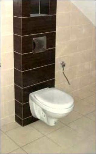 Wisząca toaleta podtynkowa Geberit z ciemnobrązową obudową w kafelki, bidetka zamontowana obok, jasne płytki podłogowe i ścienne.