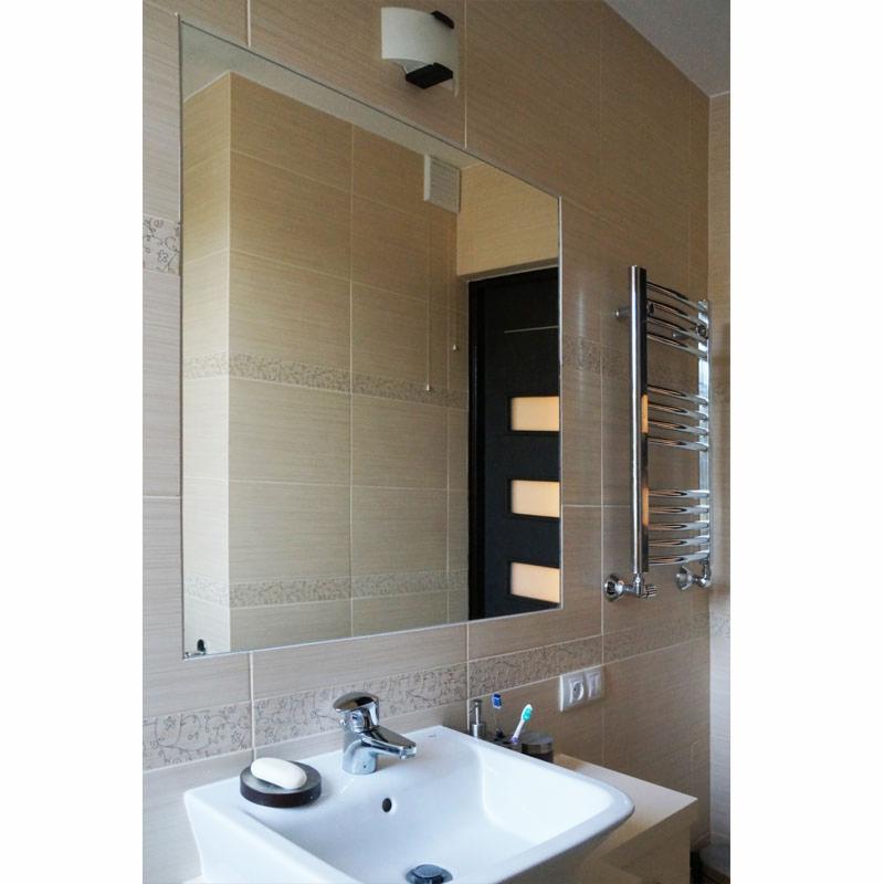 Wykończona łazienka z beżowymi płytkami, dużym lustrem bez ramy, białą umywalką nablatową i chromowanym grzejnikiem drabinkowym.