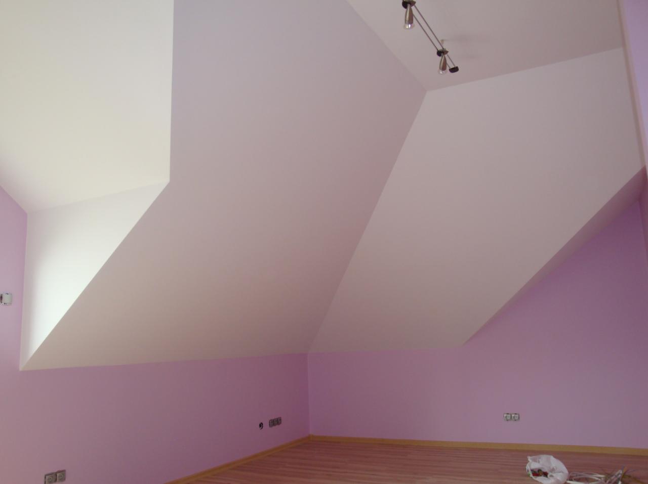 Poddasze po malowaniu: fioletowe ściany, biały, skośny sufit z zamontowanym oświetleniem punktowym, panele podłogowe.