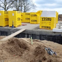 Fundamenty domu z keramzytu w Golczewie, z widocznymi paletami bloczków Ytong w żółtej folii, przygotowane do dalszej budowy.