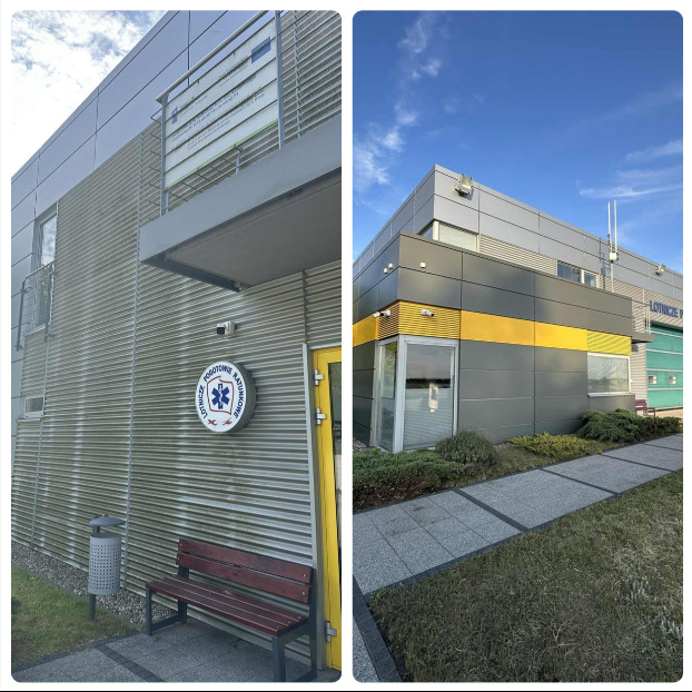 Szara elewacja budynku Lotniczego Pogotowia Ratunkowego z widocznymi śladami zabrudzeń i zacieków, kontrastująca z czystą częścią budynku po prawej stronie.