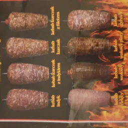 Plakat reklamowy z różnymi rodzajami kebaba, w tym drobiowy, wołowy i cielęcy, z nazwą firmy 'Michalin Kebab' i informacją o hurtowej produkcji, na tle płomieni.