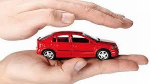 Czerwony model samochodu w dłoniach, symbolizujący ochronę i bezpieczeństwo, na białym tle.