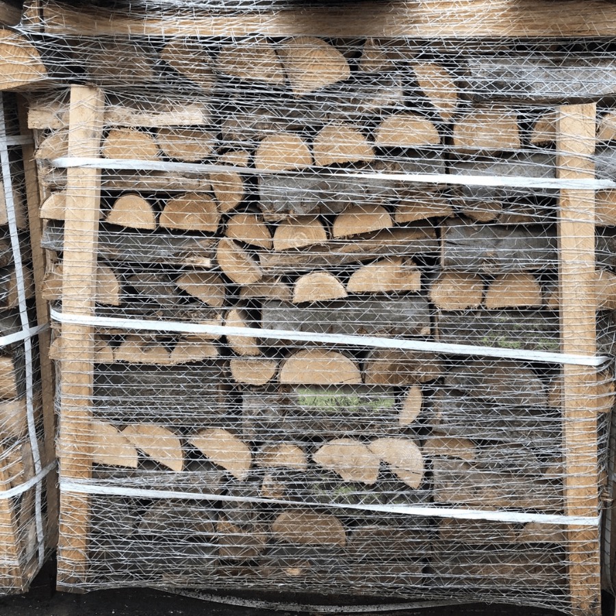 Paleta z ułożonymi kawałkami drewna opałowego, zabezpieczona siatką i białymi taśmami.