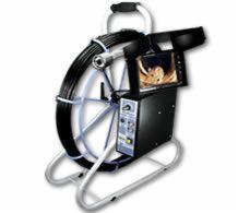 Profesjonalny sprzęt do inspekcji kanalizacji z kamerą na elastycznym przewodzie, ekran pokazujący obraz z wnętrza rury. Urządzenie na metalowym stelażu z uchwytem do przenoszenia.