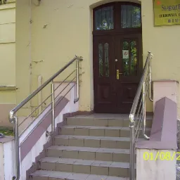 Zewnętrzne schody z metalową balustradą prowadzące do budynku Cukrowni Ostrowite. Balustrada ze stali nierdzewnej, widoczne elementy mocujące do stopni. Data na zdjęciu: 01/08/2004.