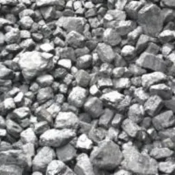 Góra czarnego węgla kamiennego o nieregularnych kształtach i zróżnicowanej wielkości, oświetlona naturalnym światłem, tworząca jednolitą teksturę.