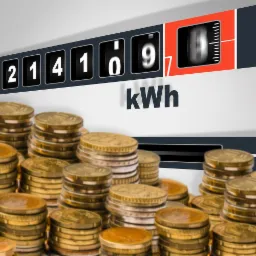 Licznik energii elektrycznej wskazujący 214169 kWh, otoczony stosami złotych monet, symbolizujący koszty energii.