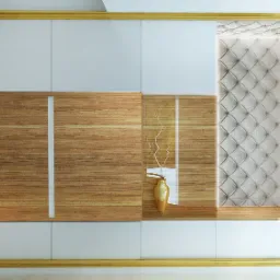 Biało-drewniana zabudowa meblowa z pikowanym panelem i złotymi akcentami. Na półce złoty wazon z gałązkami. Eleganckie i nowoczesne wykończenie wnętrza.