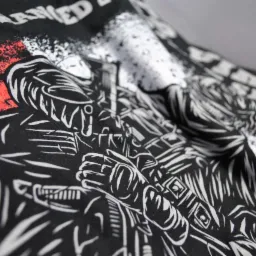 Czarna koszulka z białym, szczegółowym nadrukiem przedstawiającym postać w futurystycznym pancerzu, z czerwonym i białym efektem rozprysku w tle.