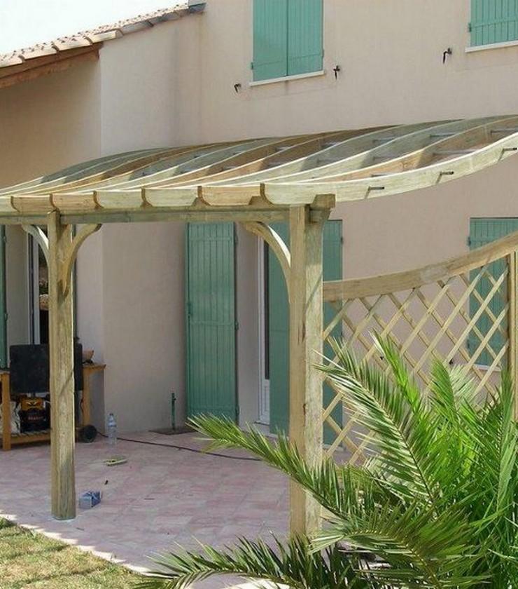 Drewniana konstrukcja z zaokrąglonym zadaszeniem, prawdopodobnie z przeznaczeniem na garaż lub zadaszone miejsce do siedzenia, przylegająca do domu z zielonymi okiennicami, z elementami ażurowego...