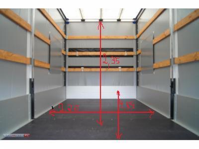 Wnętrze puste przestrzeni ładunkowej busa z drewnianymi listwami zabezpieczającymi ładunek i odręcznie naniesionymi wymiarami w centymetrach.