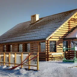 Zimowy krajobraz z drewnianym domem z bali, zadaszonym tarasem i zewnętrzną siłownią. Śnieg na dachu i wokół budynku. Widok na góry w tle.