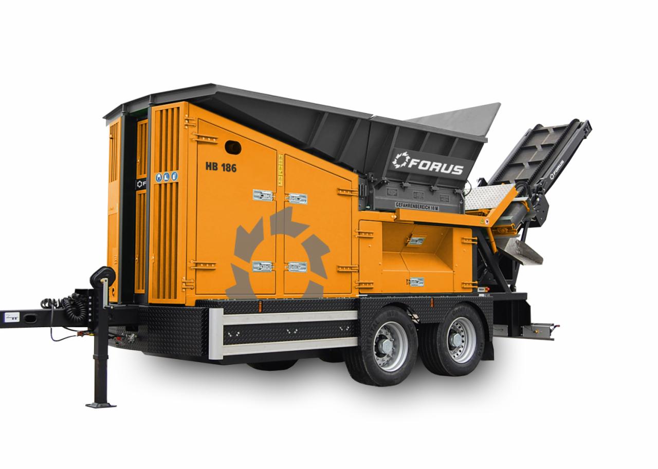Pomarańczowy rozdrabniacz wstępny FORUS HB 186 na dwuosiowej przyczepie, z podajnikiem taśmowym i szarym zbiornikiem, na białym tle.