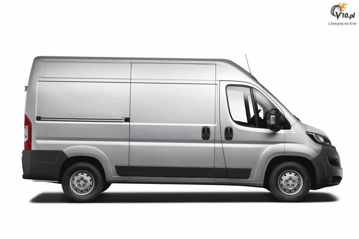 Srebrny bus dostawczy z przesuwnymi drzwiami bocznymi, widok z boku na białym tle, z logo w prawym górnym rogu.