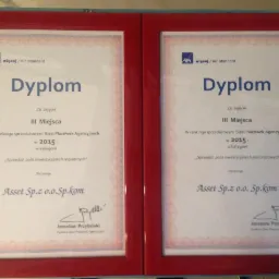 Dwa dyplomy w czerwonych ramkach, przyznane firmie Asset Sp.z o.o. Sp.kom za zajęcie III miejsca w rankingu sprzedażowym Sieci Plac&oacute;wek Agencyjnych w 2015 roku, jeden za sprzedaż polis...
