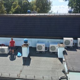 EKO-KLIMA - Montaż klimatyzatorów na dachu budynku z widocznymi pracownikami, narzędziami i jednostkami zewnętrznymi marki Gree i Seyra.