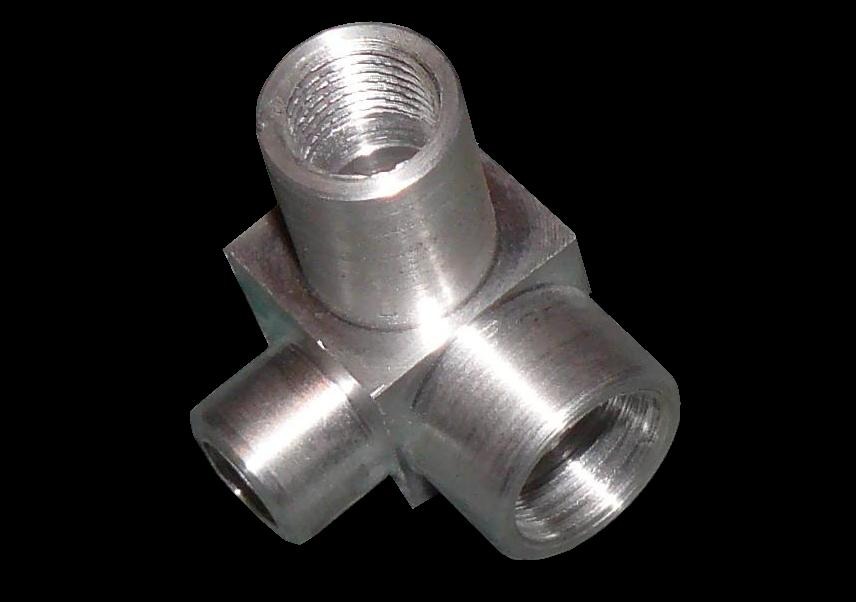 Metalowy trójnik z gwintowanymi otworami, obrobiony na tokarce, widoczne ślady obróbki skrawaniem, na czarnym tle.