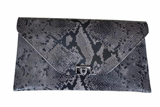Elegancka kopertówka z szarej skóry ekologicznej imitującej skórę węża, zapinana na metalowy zatrzask, leżąca na białym tle.