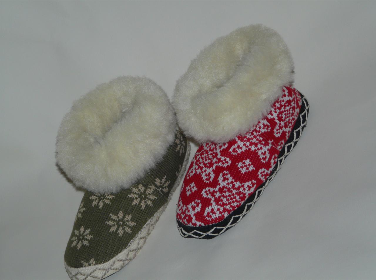 Para wełnianych kapci z wzorami: jeden zielony w śnieżynki, drugi czerwony w kwiaty. Oba z futrzanym wykończeniem. Rękodzieło.