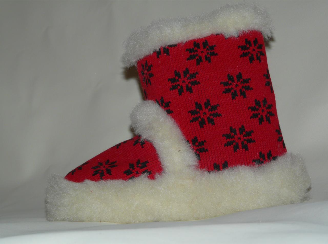 Czerwony, dziergany pantofel z czarnymi wzorami śnieżynek i białym futerkiem, widoczny z boku na jasnym tle. Ciepłe obuwie domowe.