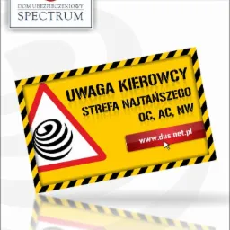 Żółta tablica ostrzegawcza 'Uwaga Kierowcy', z logo firmy ubezpieczeniowej Spectrum, hasłem 'Strefa Najtańszego OC, AC, NW' i adresem www.dus.net.pl.