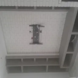 Wykończony sufit podwieszany z cegiełką i półkami w Gryficach. Widoczny uchwyt do telewizora. Nowoczesny design, precyzyjne wykonanie.