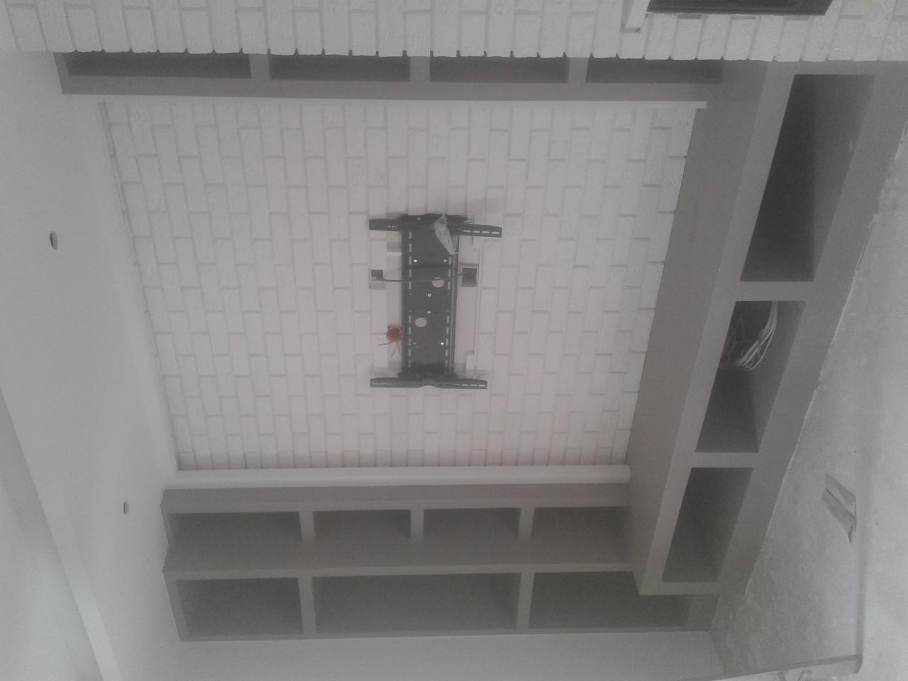 Wykończony sufit podwieszany z cegiełką i półkami w Gryficach. Widoczny uchwyt do telewizora. Nowoczesny design, precyzyjne wykonanie.