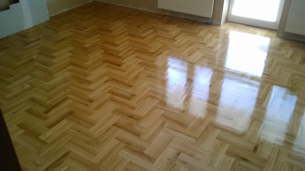 Parkiet ułożony w jodełkę, z wyraźnym połyskiem po cyklinowaniu, widoczne odbicie okna, usługa wykonana w Zwoleń.