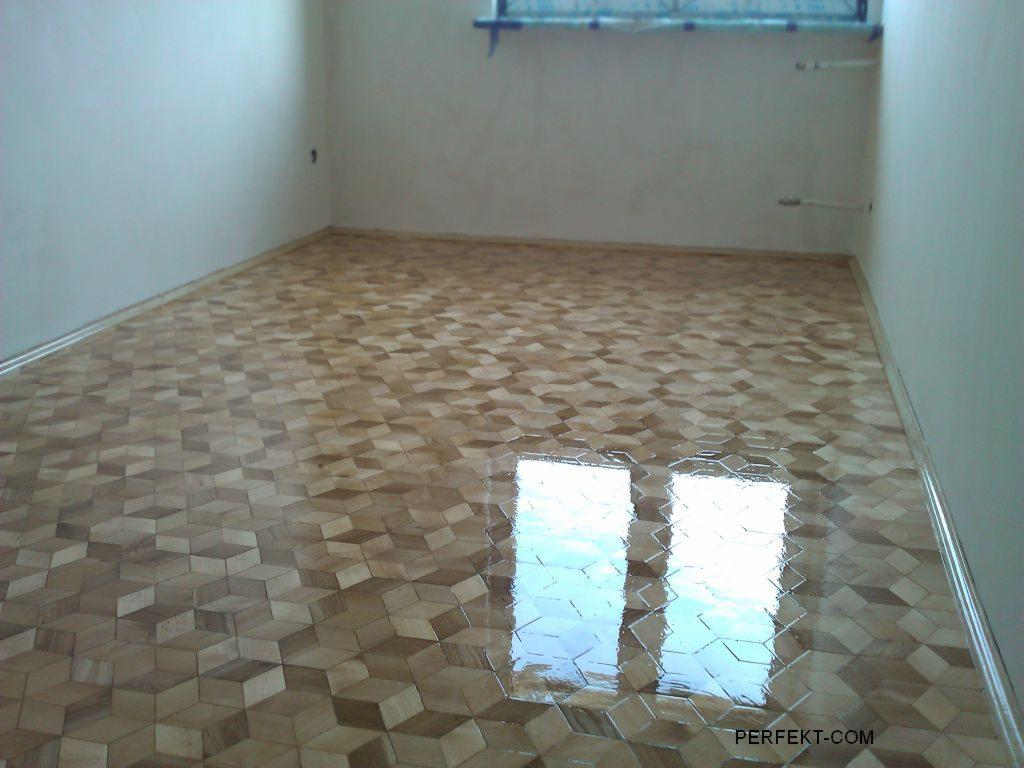 Świeżo wycyklinowana podłoga parkietowa z wzorem 3D w pustym pokoju, z widocznym odbiciem okna, po nałożeniu lakieru nabłyszczającego.