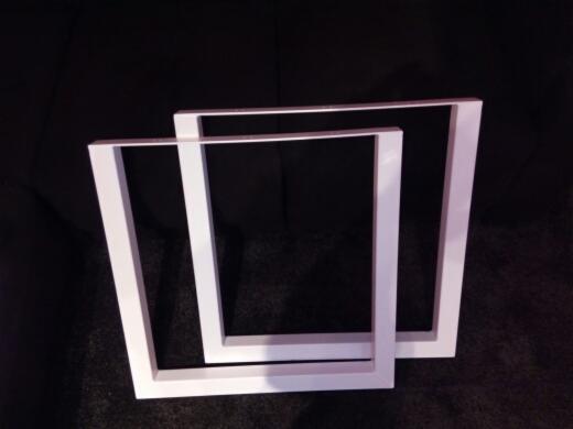 Dwie białe, kwadratowe ramy z metalowych profili na ciemnym tle, jedna rama częściowo zasłania drugą.