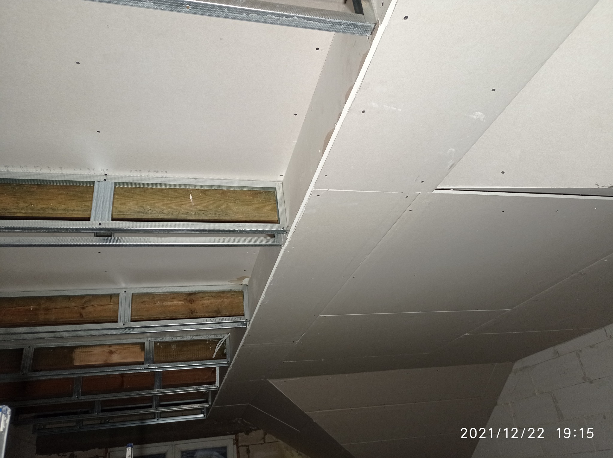 Montaż płyt karton-gips na suficie w Świerżach, widoczne profile metalowe i drewniane elementy konstrukcyjne.