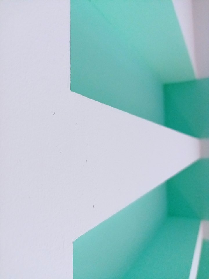 Świeżo pomalowane narożniki ścian w odcieniach bieli i pastelowej zieleni, z widoczną fakturą gładzi.