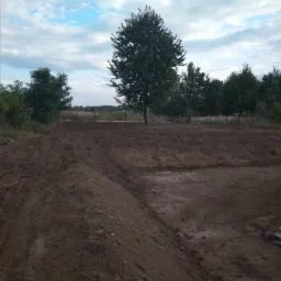 Przygotowanie terenu pod trawnik z rolki, widoczne wyrównane podłoże z drzewem w tle, data na zdjęciu 2019-09-26.